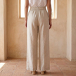FJØRNA women's linen wide-leg trousers with high waist and tailored fit, shown in a relaxed, natural stance.