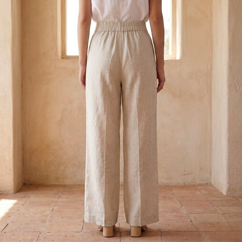 FJØRNA women's linen wide-leg trousers with high waist and tailored fit, shown in a relaxed, natural stance.
