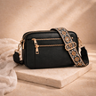 FJØRNA women's leather shoulder bag with adjustable strap, featuring a sleek design and textured brown leather surface.