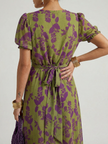 FJØRNA women's floral summer midi dress with short sleeves and wrap style, featuring a vibrant pattern and flowing fabric.