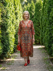FJØRNA women's summer midi dress with long sleeves, wrap style, flowy tail, and tailored fit, suitable for warm weather.