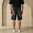 FJØRNA men's denim shorts with a floral pattern, casual summer shorts, blue denim fabric, front view showing design details.