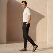 FJØRNA men's trousers featuring slim-fit design, in dark fabric with pockets, suitable for casual or smart-casual wear.