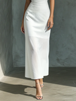 White cotton and linen blend sleeveless women's midi dress by FJØRNA, shown hanging on a wooden hanger.