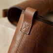 FJØRNA women's leather boots showing a stylish ankle-high design with buckle accents and smooth brown leather finish.