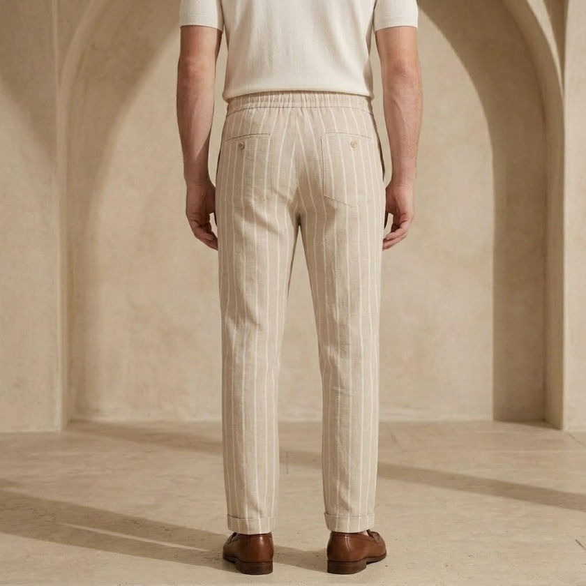 FJØRNA men's linen trousers with drawstring waist, relaxed fit, lightweight breathable fabric, shown on a model.
