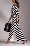 FJØRNA Statement Monochrome Stripe Asymmetric Maxi Dress in white, featuring bold black stripe patterns and flowing fabric.