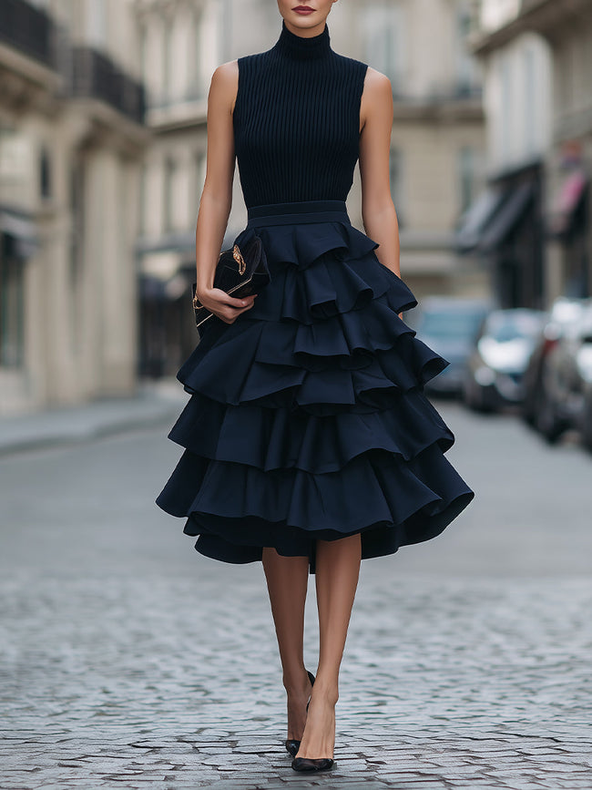 FJØRNA sleeveless high neck tiered ruffle midi dress with flowing fabric and layered ruffle details, perfect for elegant occasions.
