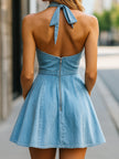 Light wash halter denim flare dress for women by FJØRNA, featuring a blue sleeveless design with a fitted bodice and flared skirt.