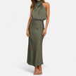 FJØRNA draped sleeveless halter maxi dress in flowing fabric, featuring a fitted waist and elegant drape detail.