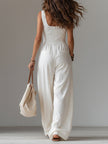 White sleeveless wide-leg jumpsuit with patch pockets by FJØRNA, featuring a relaxed fit and stylish design.