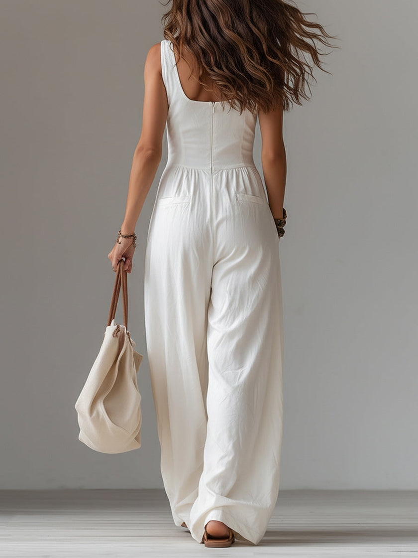 White sleeveless wide-leg jumpsuit with patch pockets by FJØRNA, featuring a relaxed fit and stylish design.