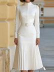 FJØRNA high-neck belted long-sleeve pleated midi dress for women, featuring a fitted waist and flowing pleated skirt.