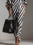 FJØRNA white monochrome stripe asymmetric maxi dress with bold pattern and flowing silhouette, perfect for elegant summer occasions.