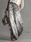 White leopard print chiffon wide-leg trousers for women by FJØRNA, featuring flowy fabric and relaxed fit.