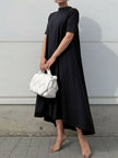 FJØRNA white high-low maxi dress with short sleeves and solid color, flowing fabric and elegant silhouette.