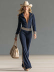 Dark blue knitted hooded zip-up V-neck jumpsuit by FJØRNA, featuring a cozy knit fabric and a stylish hooded design.