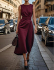 FJØRNA women's midi dress with round neck, pleated sleeveless design, flowing fabric, and elegant silhouette.