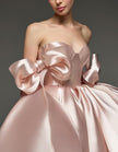 Light pink satin cocktail dress for women with sweetheart neckline and corset design featuring bow detail by FJØRNA.