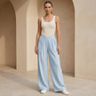 Women’s criss cross waist wide-leg trousers by FJØRNA, featuring a stylish fit and flowy fabric in a full-length view.