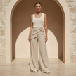 Women’s beige asymmetric waist trousers with metal buckle, stylish FJØRNA pants for a modern, chic look.
