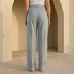 Women’s high-waisted pleated wide-leg trousers by FJØRNA, shown in a stylish fit with pleats and flowing wide-leg design.
