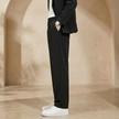 Men's pleated relaxed fit trousers by FJØRNA, showing the tailored design and comfortable fit in a neutral fabric.