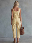 Light yellow denim jumpsuit with square neckline and zip-front from FJØRNA, featuring long sleeves and fitted design.
