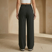 Women’s pinstripe wide-leg high-waisted trousers by FJØRNA, showing the tailored fit and pinstripe pattern on the fabric.