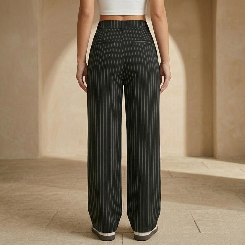 Women’s pinstripe wide-leg high-waisted trousers by FJØRNA, showing the tailored fit and pinstripe pattern on the fabric.