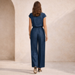 FJØRNA women's wide leg jumpsuit with V-neck, button front, and relaxed fit, shown on a model in a casual setting.