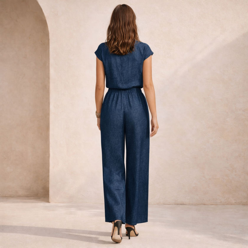 FJØRNA women's wide leg jumpsuit with V-neck, button front, and relaxed fit, shown on a model in a casual setting.