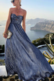 FJØRNA Celeste women’s strapless A-line evening gown with pleated metallic fabric, elegant and flowing for formal events.