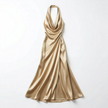 FJØRNA women's halter neck satin maxi dress displayed on a model with flowing fabric and elegant design.