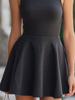 Grey FJØRNA charcoal sleeveless turtleneck flared mini dress, perfect for wedding guests, shown on a model.