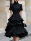 FJØRNA high neck tiered ruffle midi dress shown on a model, featuring a flowy silhouette with layered ruffles and a high neckline.