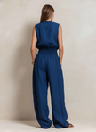 Dark blue FJØRNA women's cotton-linen jumpsuit with round neck and sleeveless, slim-fit design, styled as pants.