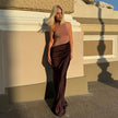 Elegant FJØRNA halter draped evening dress with flowing fabric and sophisticated design, perfect for formal occasions.