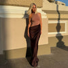 Elegant FJØRNA halter draped evening dress with flowing fabric and sophisticated design, perfect for formal occasions.