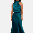 FJØRNA draped sleeveless halter maxi dress in flowy fabric, black color, with a fitted bodice and long flowing skirt.
