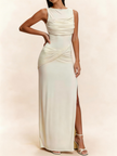 FJØRNA white sleeveless maxi dress with ruched bodice and side slit, flowing floor-length design for elegant summer wear.