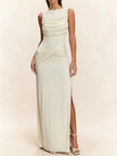 White FJØRNA sleeveless maxi dress with ruched bodice and thigh-high slit, flowing fabric and elegant design.