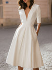 FJØRNA elegant deep V-neck pleated A-line midi dress shown in a stylish dress image with flowing fabric and sophisticated design.