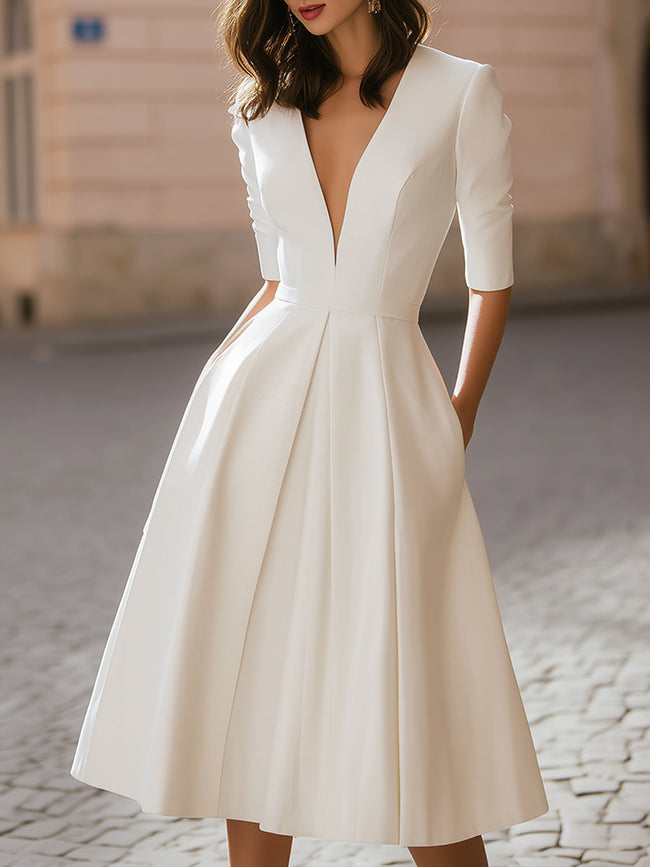 FJØRNA elegant deep V-neck pleated A-line midi dress shown in a stylish dress image with flowing fabric and sophisticated design.