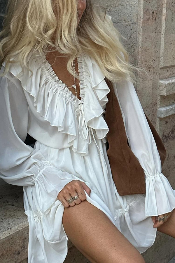 FJØRNA solid color V-neck ruffled ruched long-sleeved vacation mini dress, casual wedding dress style, shown on a model.
