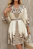FJØRNA champagne mini dress with printed V-neck, lantern sleeves, and waist tie, perfect for stylish occasions.
