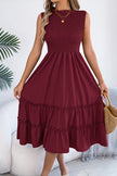 FJØRNA solid color sleeveless tucked patchwork casual midi dress hanging on a mannequin, showcasing its design and fabric details.