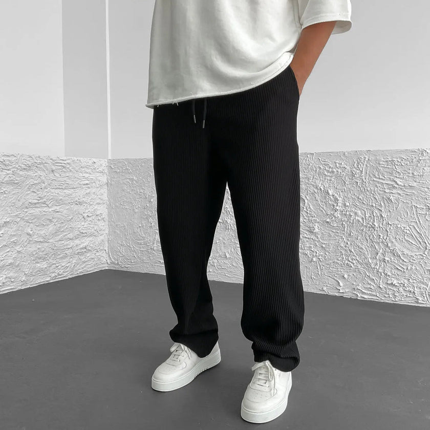 FJØRNA relaxed khaki knit trousers laid flat, showing soft fabric, relaxed fit, and classic style for casual wear.