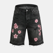 Men's floral denim shorts by FJØRNA with distressed details and casual fit, shown on a model.