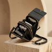 FJØRNA women's crossbody bag in black with adjustable strap, compact and stylish for everyday use.